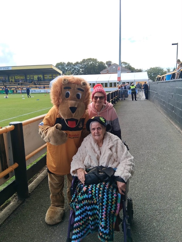 resident and carer with lion football mascot