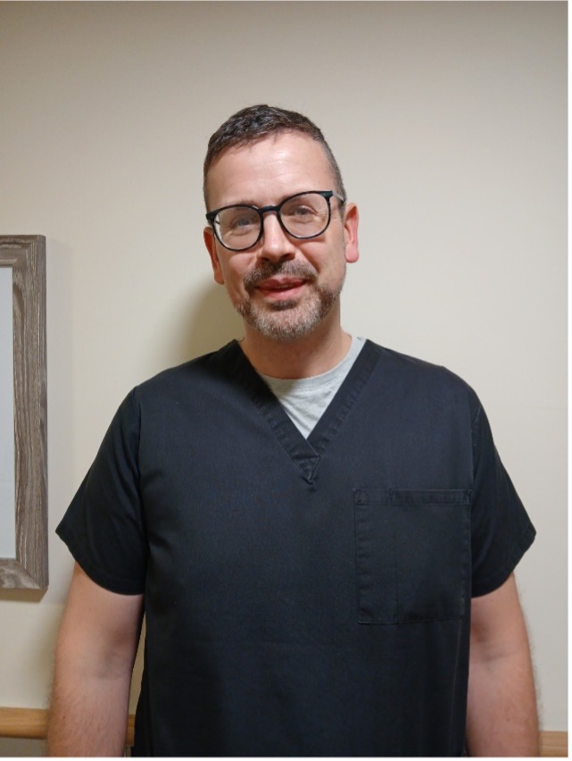 man with glasses posing for staff photo
